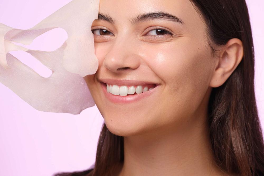 Eine weibliche Person nimmt eine Gesichtsmaske ab
