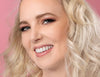 Frau mit Make-up das sich eignet um Hautprobleme abzudecken lächelt