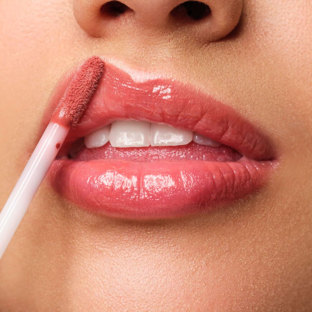 Close-up auf eine Lippe, auf welche das Plumping Lip Fluid N°28 augetragen wird. Jetzt zusammen mit passenden Lip Liner im Set shoppen.