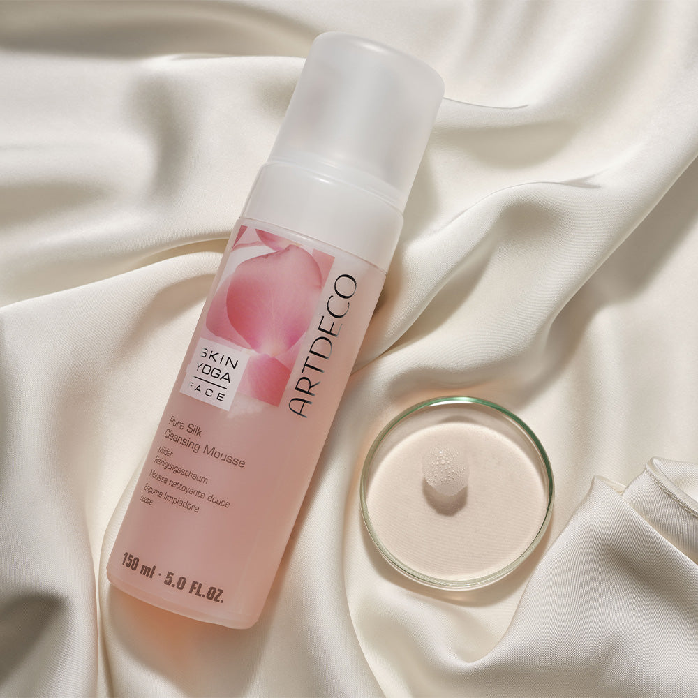 Pure Silk Cleansing Mousse liegt auf einem hellen. seidenen Hintergrund