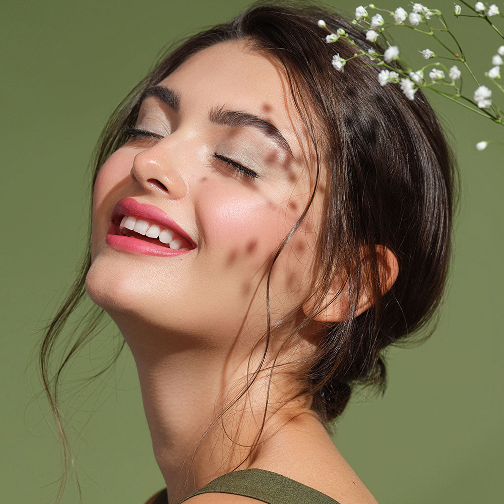 Frau geschminkt mit naturnahen Green Couture Produkten hat die Augen geschlossen und lächelt dabei