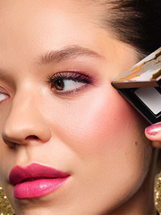 Model mit einem festlichen Look hält eine befüllte Beauty Box neben ihr Augen-Make-up