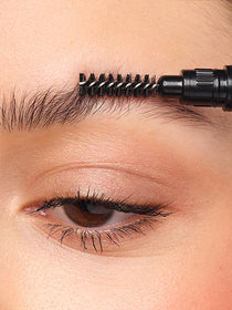 Ungeschminkte Augenbrauen werden mit dem Kämmchen des Sculpting Brow Styler nach oben gekämmt.