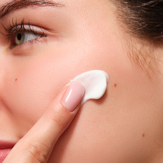 Pure Silk Moisture Mask wird auf die Wange des Models aufgetragen