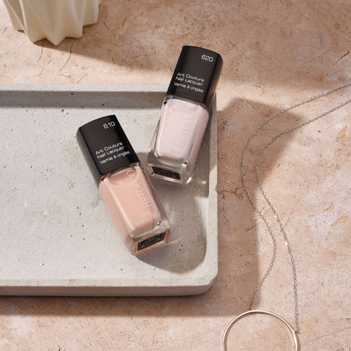 Zwei Nuancen des Art Couture Nail Lacquers platziert auf einem Tablett aus Stein. (Nummer 610 und 620)