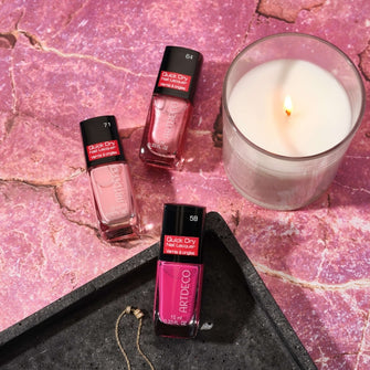Drei Quick Dry Nail Lacquer auf pinken Marmor Hintergrund