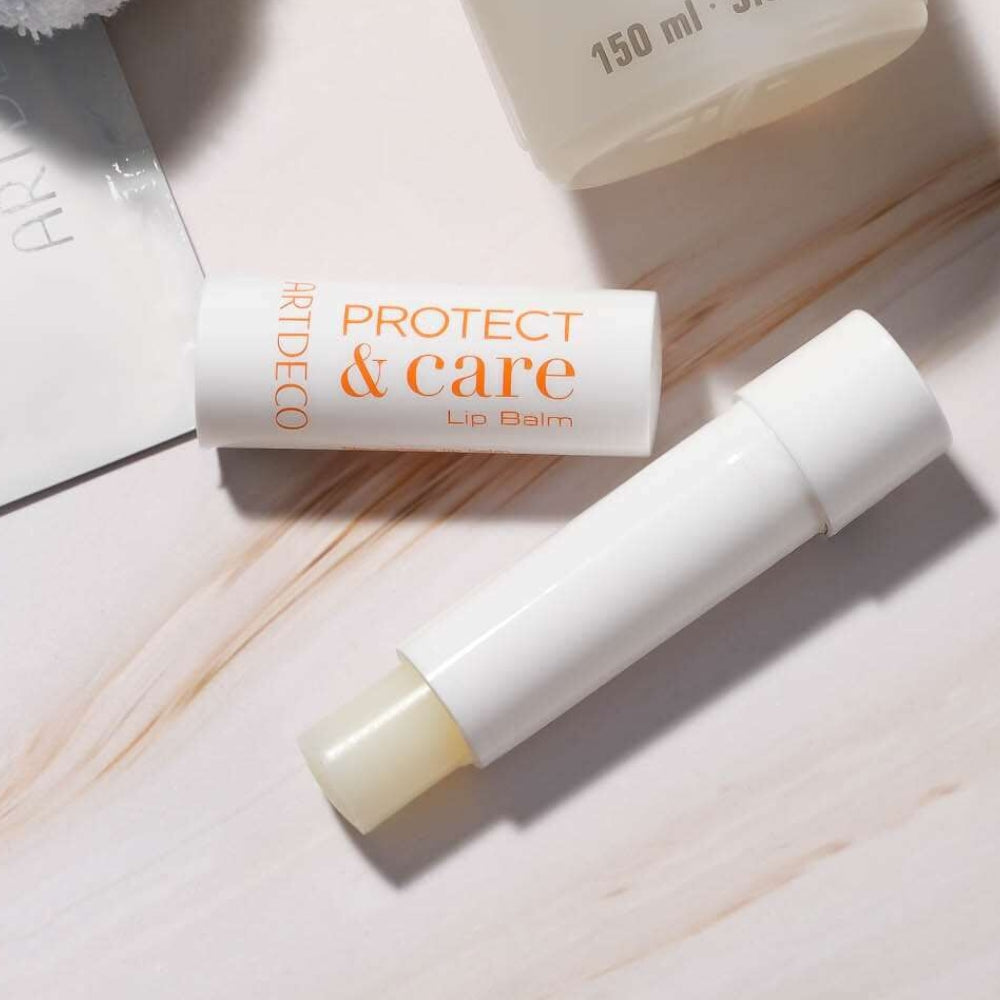Der Protect & Care Lip Balm liegt geöffnet auf einer Marmorfläche