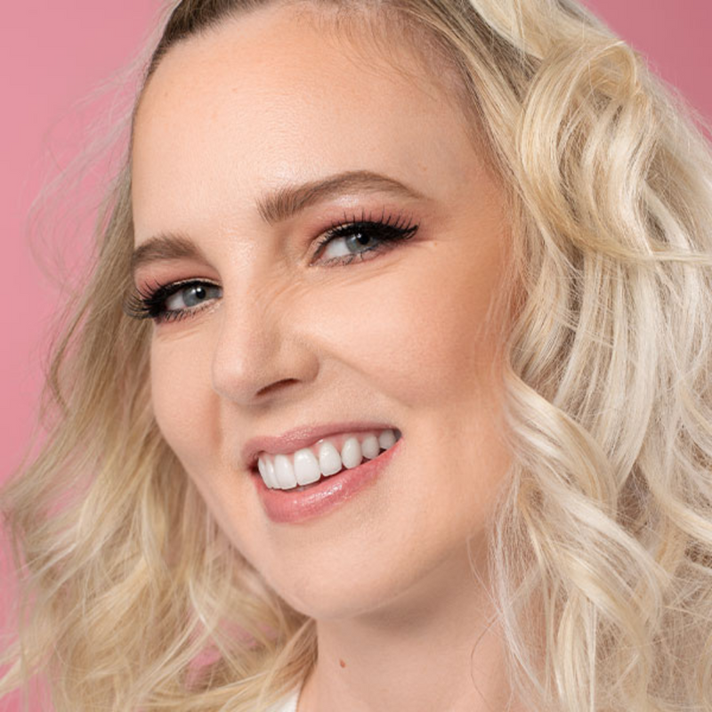 Frau mit Make-up das sich eignet um Hautprobleme abzudecken lächelt