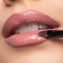 Lippen Close-up auf welchen mit einem Pinsel Lippenstift aufgetragen wird