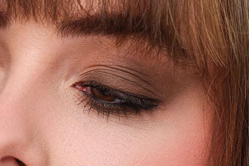Man sieht ein in Brauntönen geschminktes Auge von einer Frau