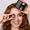 Model mit rötlichen Haaren hält Beauty Biox mit dazugehörigen Lidschatten aus der 40 Jahre ARTDECO-Kollektion in der Hand und lächelt dabei