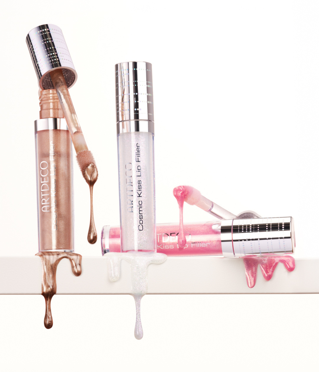 Alle drei Cosmic Lip Filler stehen geöffnet auf einem weißen Flächen und an ihren Seiten läuft die Textur des Produktes auf ästhetische Weise runter.