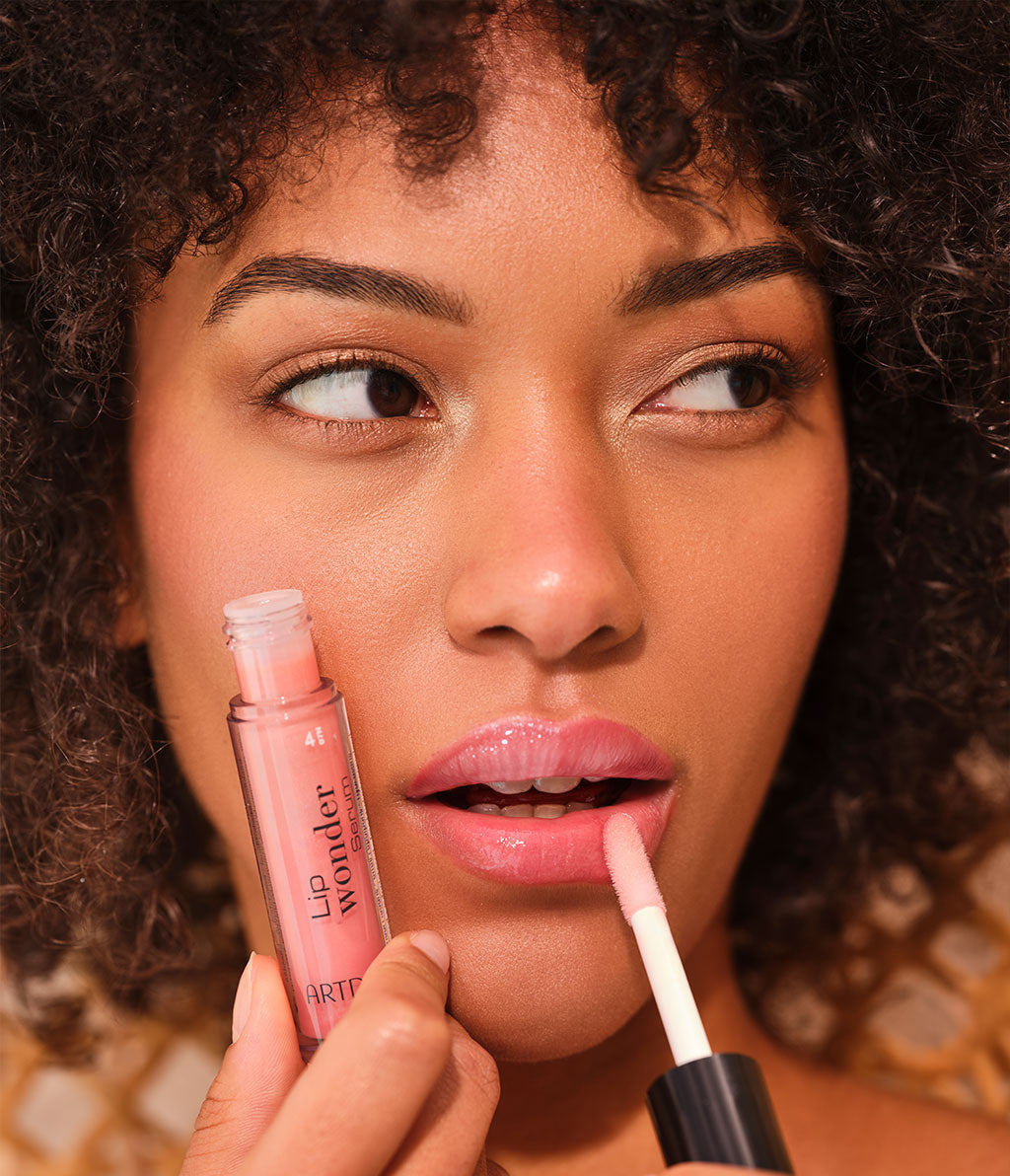 Close-up auf das Model, welches eine der vier Farben des Lip Wonder Serums aufträgt für gepflegte Lippen mit dezenter Farbe.