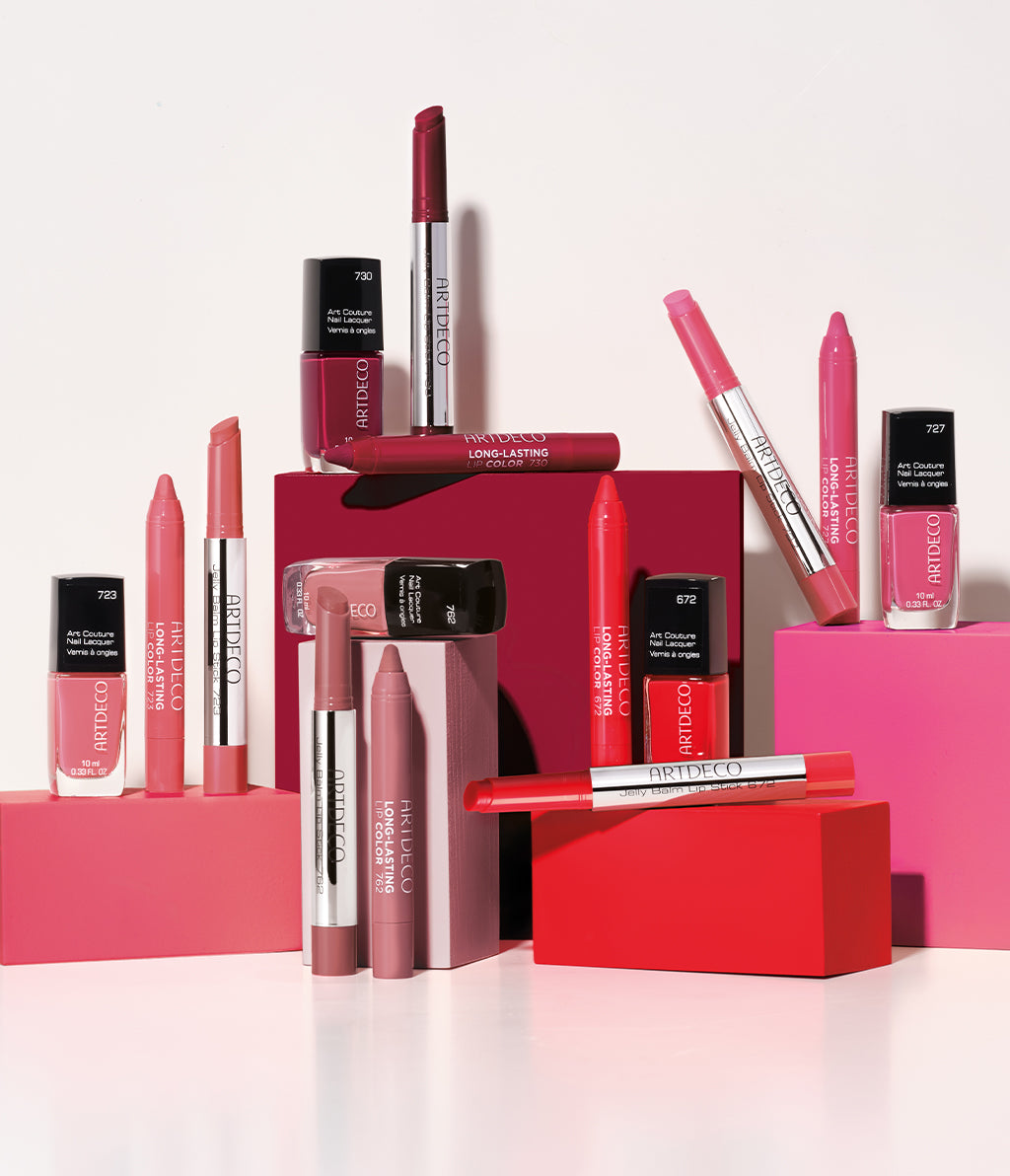 Alle Produkte der Kollektion, bestehend aus perfekt aufeinander abgestimmten Lippenstiften und Nagellacken, auf farblich zusammenpassenden Klötzen platziert.