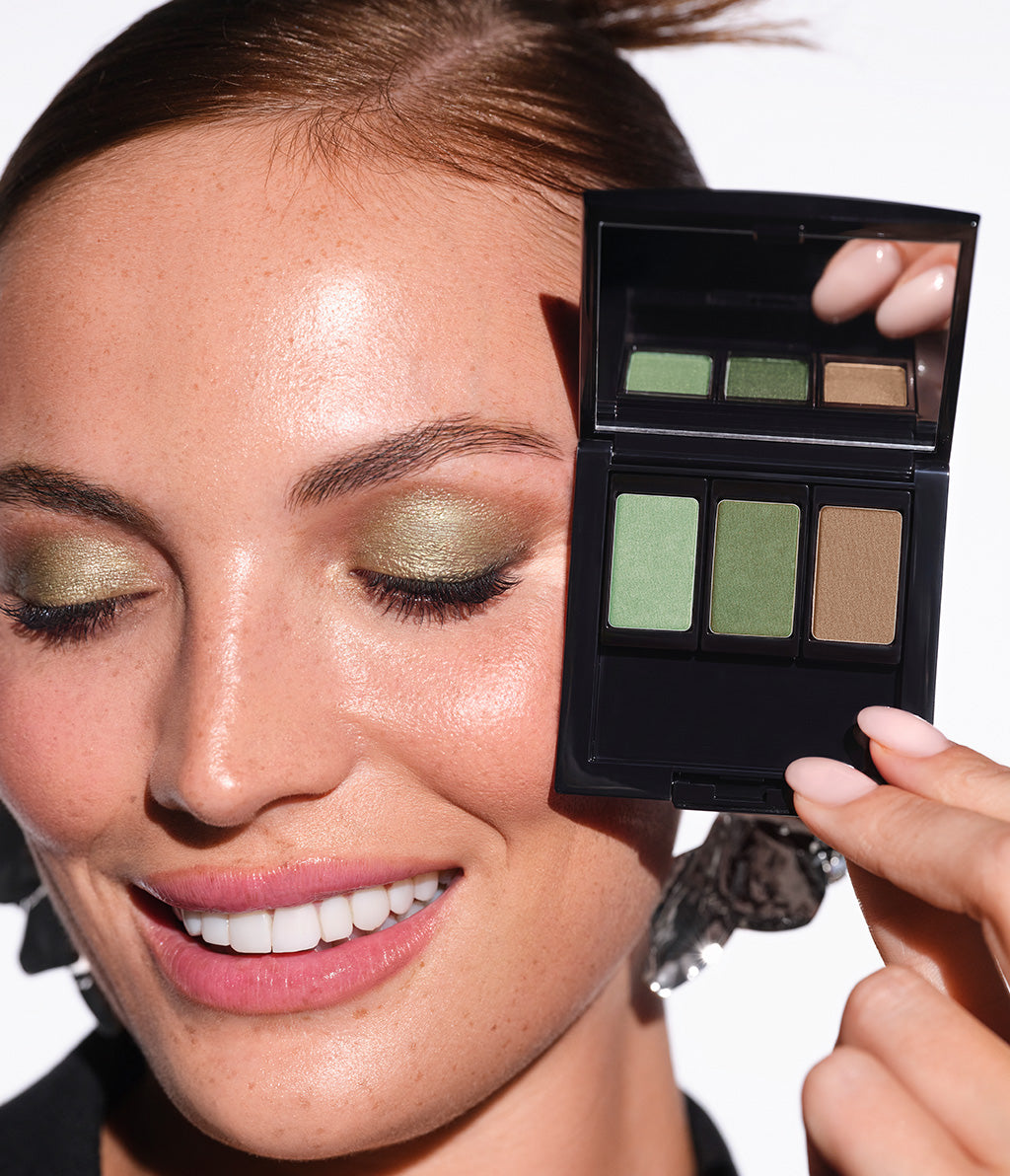 Close-up auf die Auegn des Rothaarigen Models. Für ihr Augen-Make-up trägt sie die Lidschattenfarben N°39, N°40 und N°208 und hält die befüllte Beauty Box neben dem geschminkten Look.