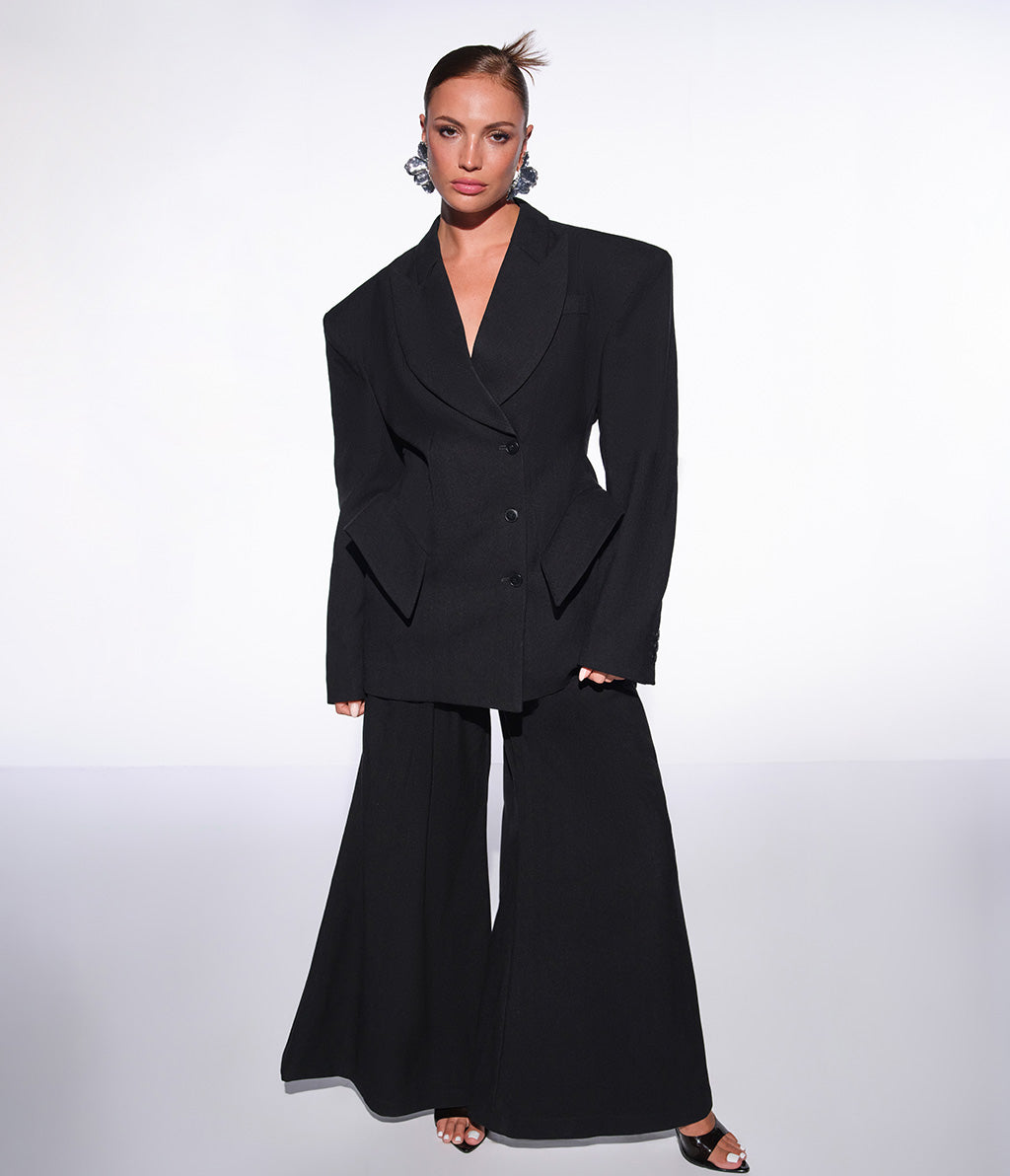 Moodbild von dem rothaarigen Model in einem eleganten schwarten Blazer und silbernen Accessoires