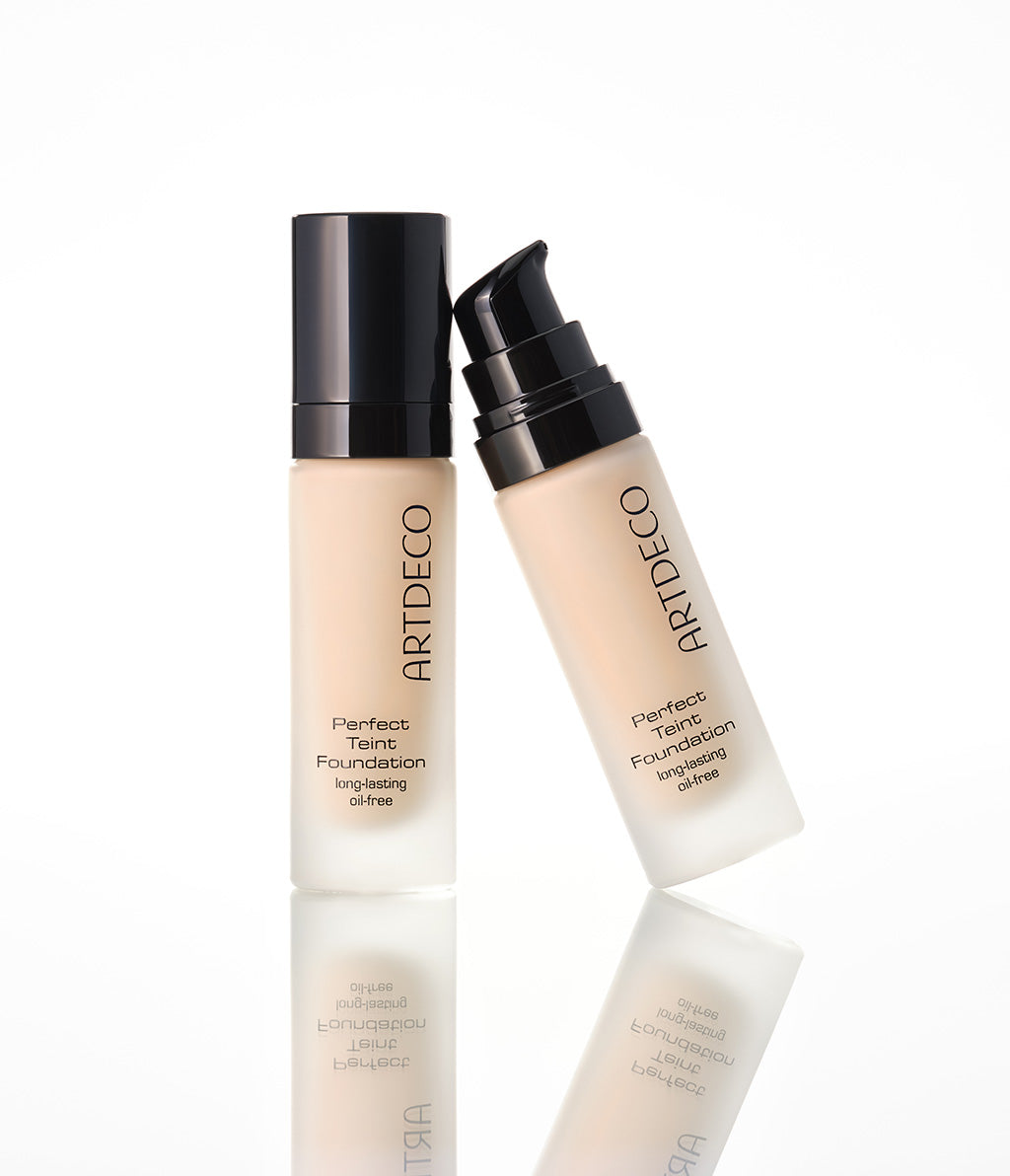 Zwei Perfect Teint Foundation stehen auf einem hellen Untergrund. Es entsteht ein leichter Spiegel-Effekt für ein hochwertuges Gefühl