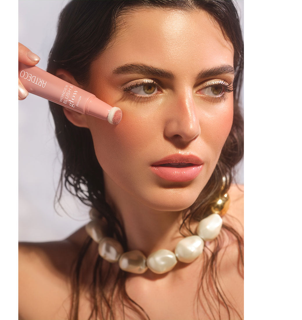 Brünettes Model mit glowy Make-up und einem natürlich, Frischen Teint trägt den Wonder Blush & Glow Rouge mit dem Schwämmchenapplikator auf ihre Wange auf, und dieses Ergebnis zu erzielen