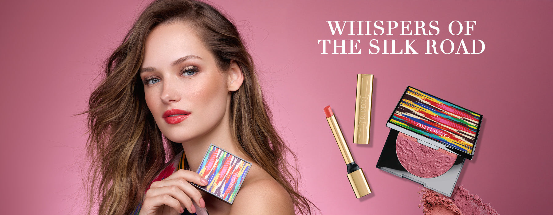 Model hält den limitierten Blush Couture in der Hand. Auf rosa Hintergrund steht zusätzlich der Name der Kollektion »Whispers of the Silk Road« und zwei Produkte, welche besonders hervorgehoben werden sollen: Der neue Lip Shine Stylo als auch der Blush Couture im limitierten Design