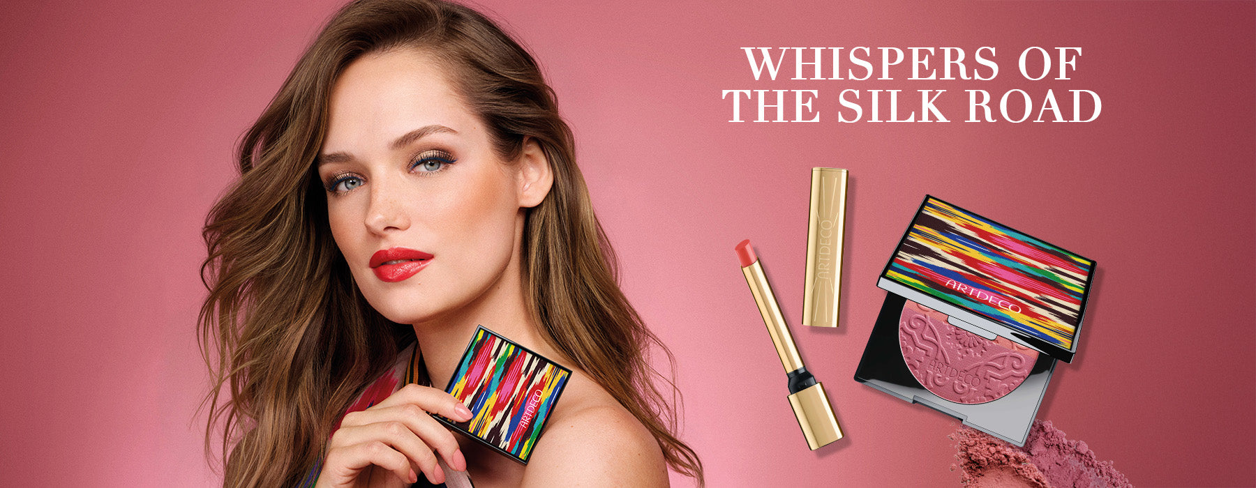 Model hält den limitierten Blush Couture in der Hand. Auf rosa Hintergrund steht zusätzlich der Name der Kollektion »Whispers of the Silk Road« und zwei Produkte, welche besonders hervorgehoben werden sollen: Der neue Lip Shine Stylo als auch der Blush Couture im limitierten Design