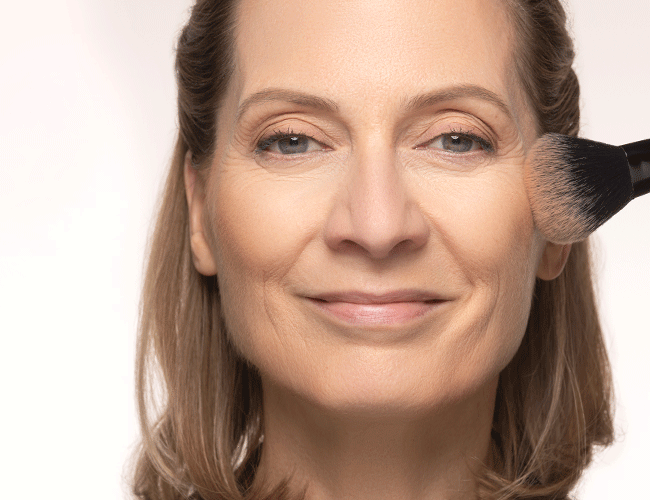 Bronzer und Rouge werden auf den Wangen aufgetragen um ihnen Wärme und Frische zu verleihen