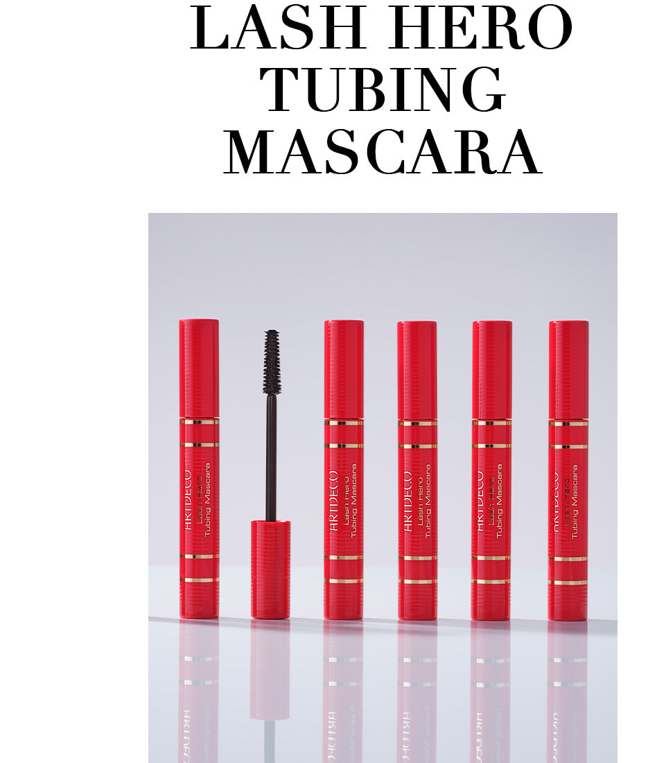 Fünf geschlossene Lash Hero Tubing Masaras im limitierten roten Design Lip stehen geschlossen aufgereiht auf einem neutralen Hintergrund. Außerdem wird zusätzlich das Bürstchen der Mascara gezeigt. Zudem steht in Großbuchstaben der Name des Produktes »Lash Hero Tubing Mascara«.