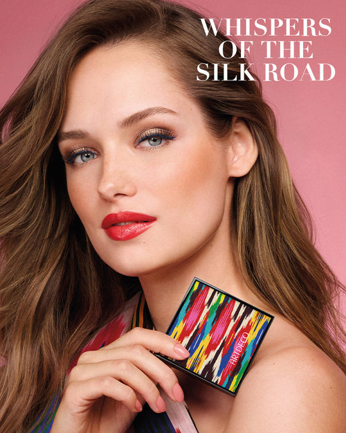 Model hält den limitierten Blush Couture in der Hand und auf dem rosa Hintergrund steht zusätzlich der Name der Kollektion »Whispers of the Silk Road«.