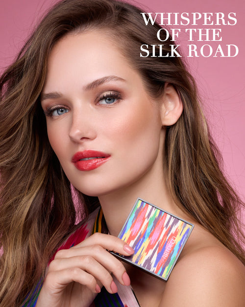 Model hält den limitierten Blush Couture in der Hand und auf dem rosa Hintergrund steht zusätzlich der Name der Kollektion »Whispers of the Silk Road«.