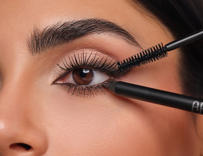 Nahaufnahme eines Augen-Make-ups mit voluminös getuschten Wimpern, die das Abend Make-up abschließen.