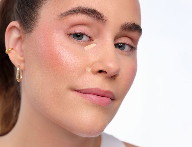 Model trägt den ARTDECO Perfect Teint Illuminator unter dem Auge und an der Nase auf, um Schatten zu neutralisieren.