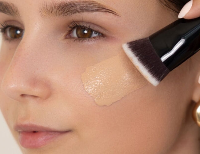 Model trägt eine flüssige Foundation  für das Latte Make-Up auf.