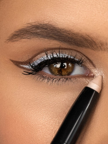 Nahaufnahme eines geschminkten Auges mit silbrigem Lidschatten und braunem Lidstrich.