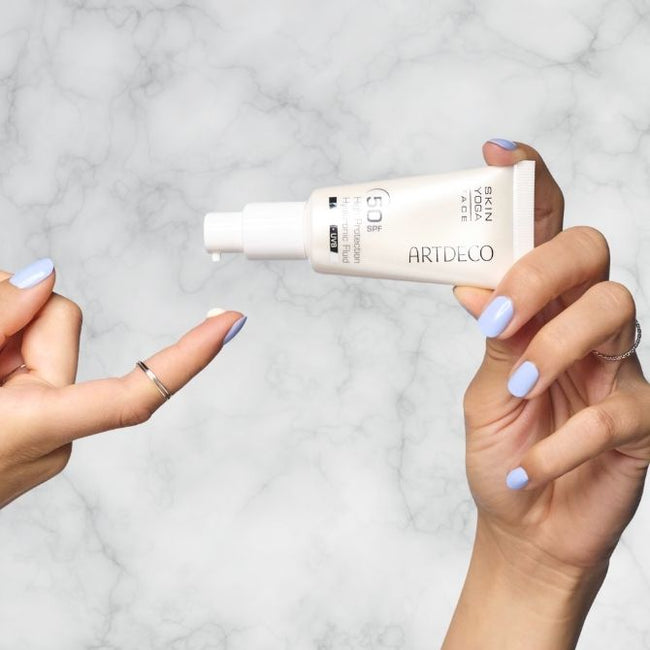 Sonnenschutz wird auf einen Finger getropft.