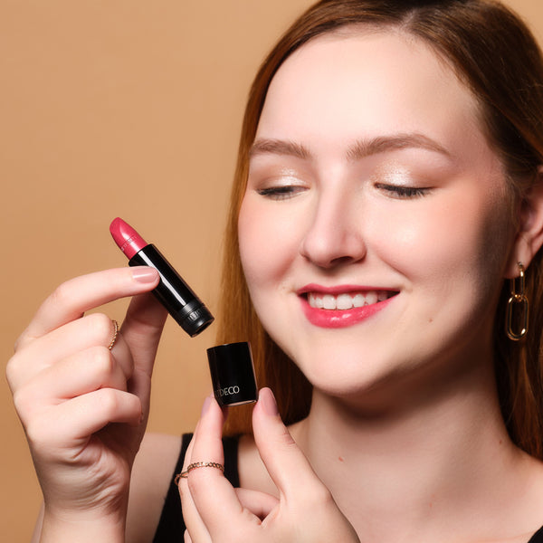 Model hält Couture Lipstick Refill und hat das Produkt an den Lippen angewendet