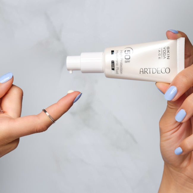 Das High Protection Hyaluronic Fluid SPF 50 wird auf die Finger aufgetragen um es anschließend auf das Gesicht aufzutragen.
