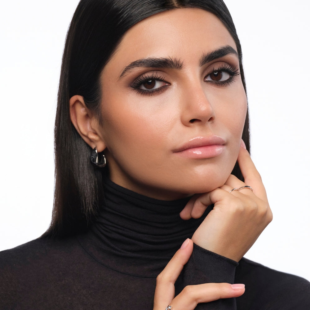 Model mit intensiv geschminkten Smokey Eyes in dunklen Braun und Schwarztönen für einen ausdrucksstarken Augen Make-up Look.