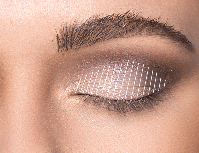 Heller, schimmender Lidschatten wird auf das bewegliche Lid aufgetragen um Highlights zu setzen