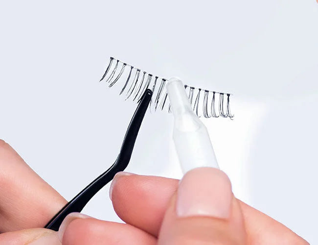 Der Kleber wird auf die Bandwimpern aufgetragen