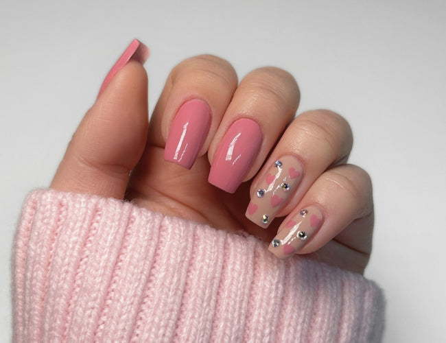 Neben die gezeichneten Herzen werden Glitzersteinchen mit dem Gel Look Top Coat geklebt. 